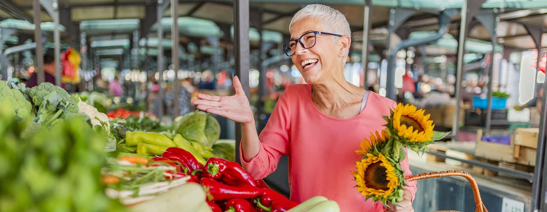 A women smiling while shopping at a large farmers market